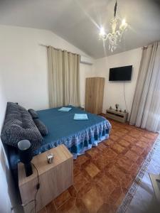 a bedroom with a blue bed and a flat screen tv at Villa Julieta in Scalea