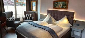 a bedroom with a large bed and two chairs at Haus Montana in Lermoos