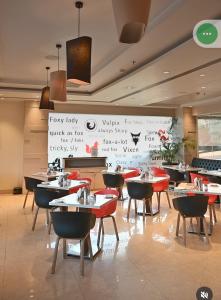 a restaurant with tables and chairs and writing on the wall at Red Fox by Lemon Tree Hotels, Alwar in Alwar