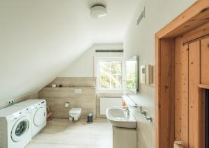a bathroom with a sink and a washing machine at Schneekäppchen 2 in Winterberg +29 photos