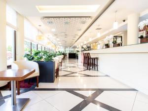a restaurant with a bar and tables and chairs at Ośrodek Delfin in Dąbki +25 photos