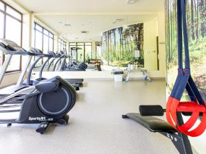 a gym with treadmills and ellipticals in a room at Ośrodek Delfin in Dąbki