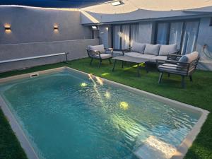 a swimming pool in a yard with a couch and chairs at אחוזת ישי-אברהם in Tiberias