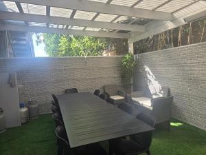 a patio with a table and chairs and a brick wall at אחוזת ישי-אברהם in Tiberias
