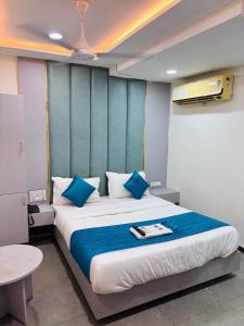 a bedroom with a large bed with blue pillows at Hotel Sun Park in Ahmedabad
