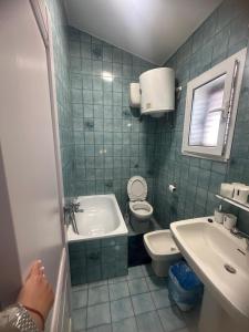 a blue tiled bathroom with a toilet and a sink at Villa Julieta in Scalea +14 photos