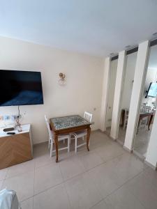 a living room with a table and a tv on a wall at חדר לים הרצליה in Herzliya B
