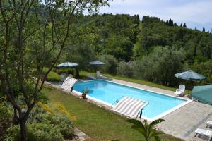 a swimming pool with two lawn chairs and umbrellas at Agriturismo Montereggi in Fiesole