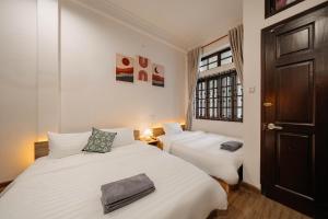 a bedroom with two beds and a window at Exia House in Ho Chi Minh City