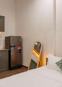 a small kitchen with a bed and a refrigerator at Exia House in Ho Chi Minh City