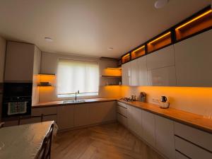 a kitchen with white cabinets and a sink and a window at Sea Breeze House Ureki in Ozurgetʼi