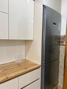 a kitchen with white cabinets and a stainless steel refrigerator at Sea Breeze House Ureki in Ozurgetʼi +13 photos