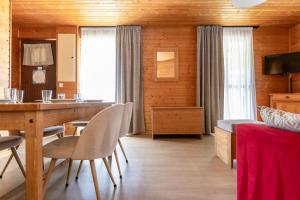 a living room with a dining room table and chairs at Résidence Odalys Les Chalets d'Evian in Évian-les-Bains