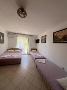 a room with three beds in it with a window at Villa Đeković in Čanj