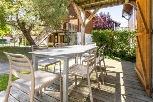 a white table and chairs on a wooden deck at Résidence Odalys Les Chalets d'Evian in Évian-les-Bains