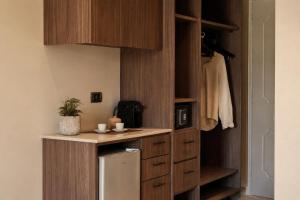 a kitchen with wooden cabinets and a refrigerator at Ilios Hotel, Adults Only in Laganas