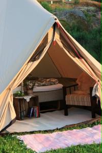 a tent with a bed and a table in it at Jennys tent in Saltvik