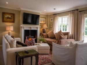 a living room with couches and a fire place at Lower Colworth Lodge in Chichester