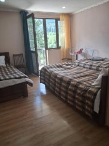 a bedroom with two beds and a table and chairs at Lama inn in Mestia