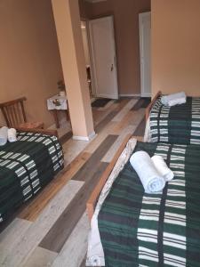 two beds in a room with wooden floors at Lama inn in Mestia