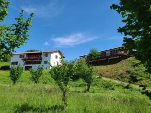 a house on a hill with trees in the foreground at La Noisette Basque - Nuits au verger in Saint-Pée-sur-Nivelle