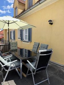 a table with chairs and an umbrella on a patio at Ferienwohnung Altes Rüsthaus in Ilz