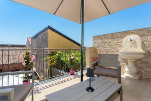 a patio with a bench and an umbrella at Perla Dell'Etna Holiday House in Zafferana Etnea
