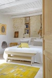 a white bedroom with two beds and a table at Maison Forte in Montcuq