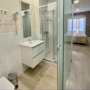 a white bathroom with a shower and a sink at Hostal Madrid in Madrid +58 photos