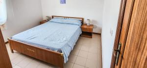 a small bedroom with a bed and a night stand at Casa delle Farfalle in Cariati