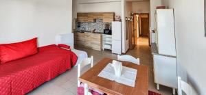 a living room with a red bed and a table at Casa delle Farfalle in Cariati