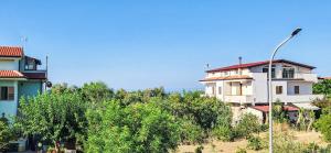a building on a hill with trees and a street light at Casa delle Farfalle in Cariati