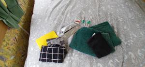 a pile of cleaning items sitting on a bed at Pipowagen bij Sneek, voor maximaal 2 personen in Hommerts