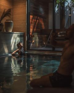 a woman is sitting in a swimming pool at Sense Hotel Sofia, a Member of Design Hotels in Sofia