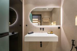 a bathroom with a white sink and a mirror at Hotel Areti in Neos Marmaras +105 photos