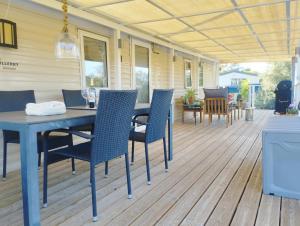 a porch with a table and chairs on a deck at The Hillside Lodge in Pizarra