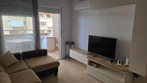 a living room with a couch and a flat screen tv at Vistamar -primera linea de playa in El Borseral