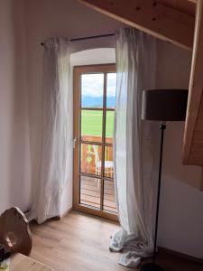 a room with a window with curtains and a view at Ferienwohnung Grecht in Uffing