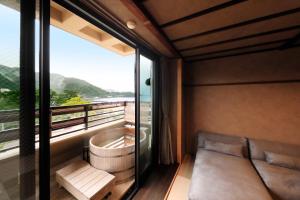 a room with a couch and a large window at 西伊豆 巡り in Ukusu