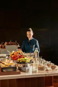 a woman standing in front of a table of food at Lido Palace - The Leading Hotels of the World in Riva del Garda +244 photos
