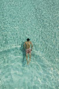 a man walking in the water in the ocean at Lido Palace - The Leading Hotels of the World in Riva del Garda
