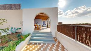 a house with a staircase leading to a balcony at Okto in Archangelos
