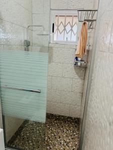 a bathroom with a shower with a glass door at His Goodness - Apt Two! in Kampala +60 photos