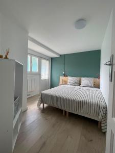 a bedroom with a bed with a green wall at Maison La Petite Pause in Bray-Dunes
