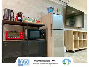 a kitchen with a microwave and a refrigerator at Lucky House B&B in Jiufen