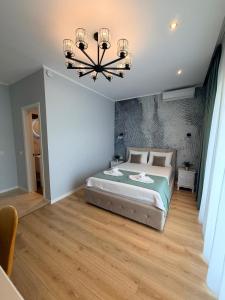 a bedroom with a large bed and a chandelier at Kaleh Boutique Villa in Orşova +45 photos