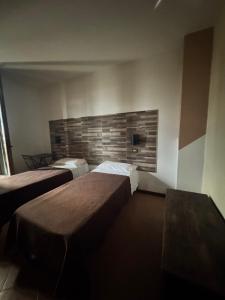 a room with two beds and a bench in it at B&b Romani in Bologna
