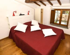 ein Schlafzimmer mit einem großen roten Bett und weißen Kissen in der Unterkunft Baduerughe - ValledelLago in Poggio Mirteto