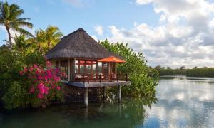 a small island in the water with a house at Constance Prince Maurice in Post of Flacq
