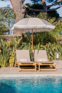 two chairs and an umbrella next to a pool at Auberge TAO in Biot